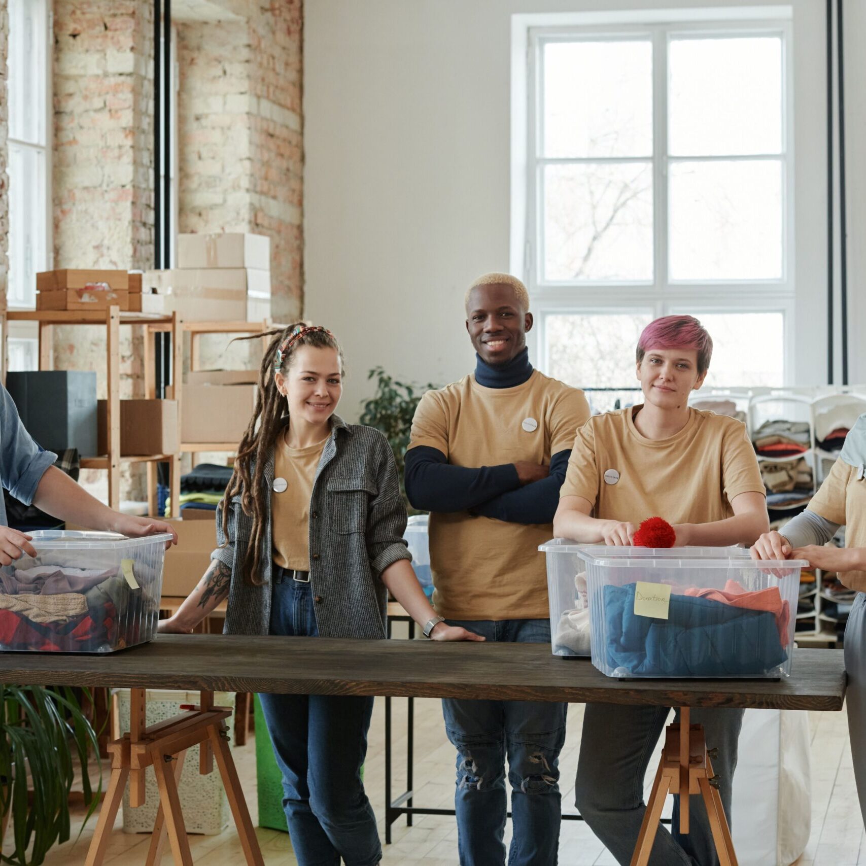 A diverse team of volunteers sorts clothing donations in an organized workspace, promoting community support.